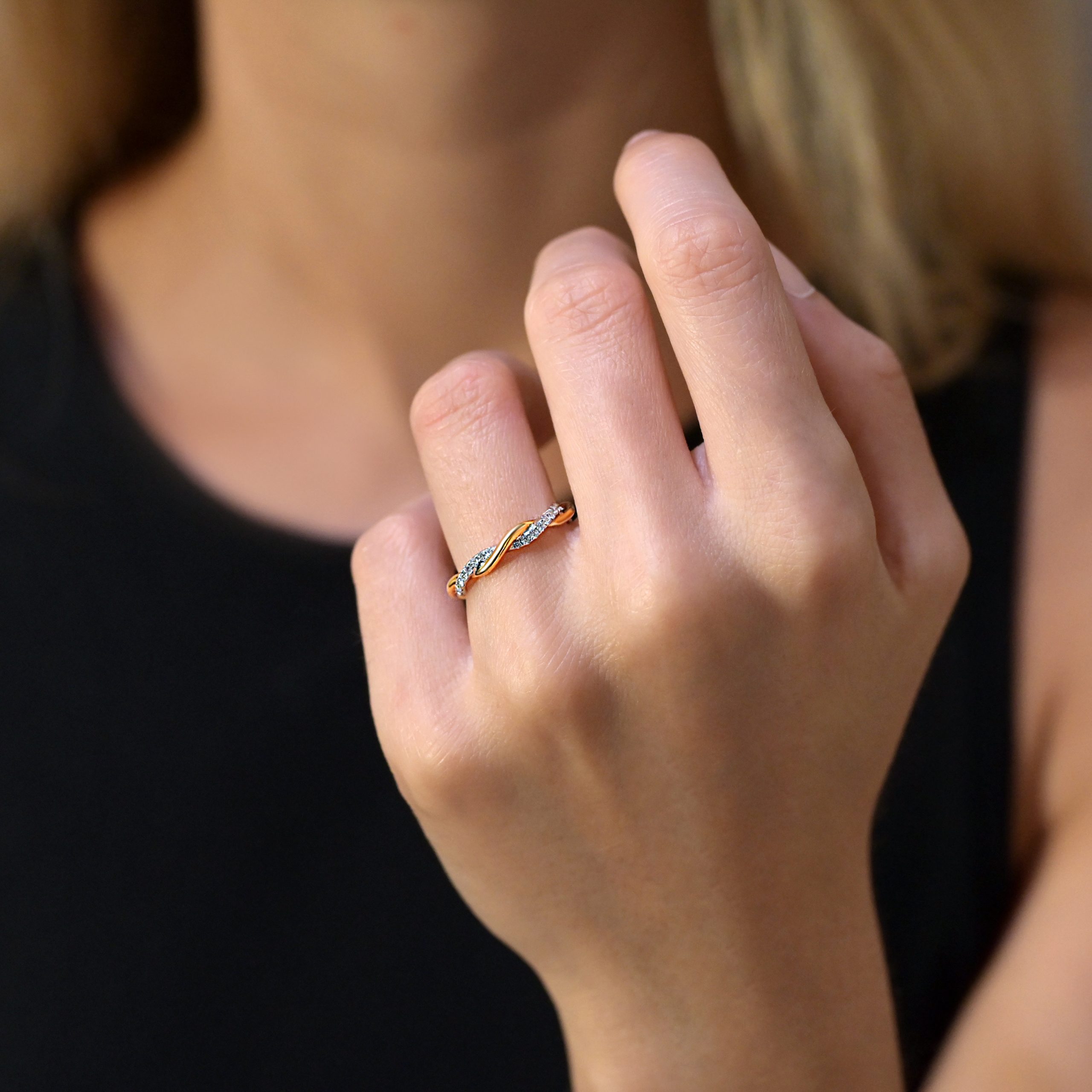 Diamond wedding ring with intertwined yellow and white gold bands and pave diamonds.