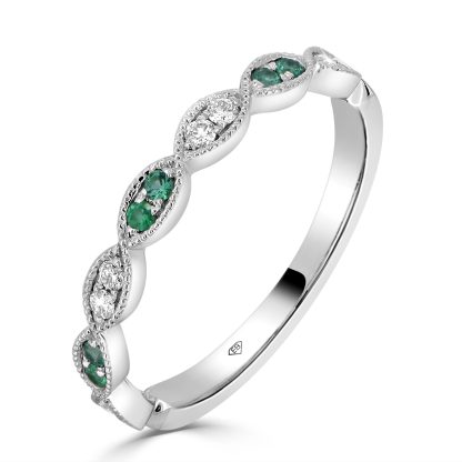 Diamond band wedding ring with emerald accents in 18ct white gold, featuring milgrain detailing and marquise-shaped settings.