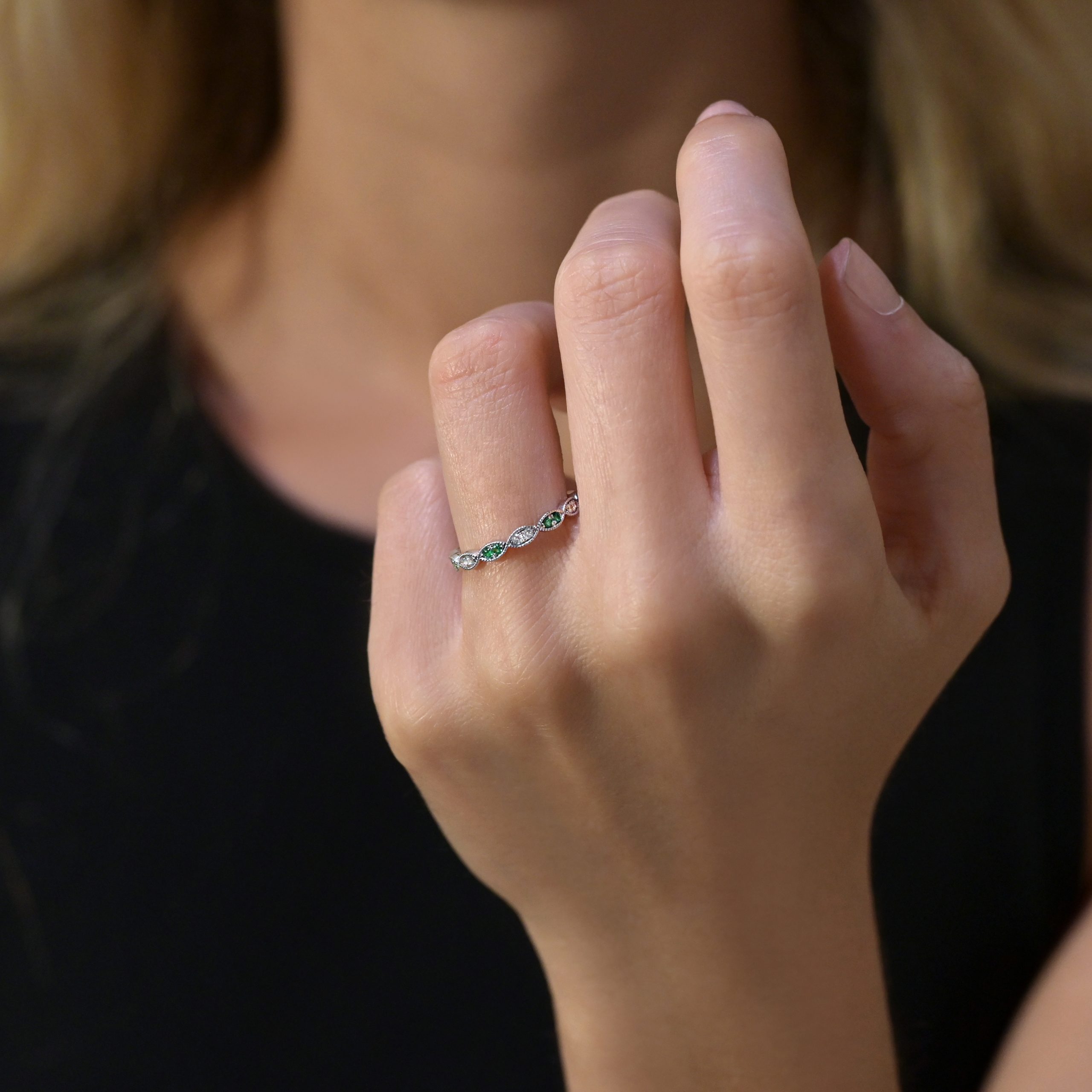 Diamond band wedding ring with emerald accents in 18ct white gold, featuring milgrain detailing and marquise-shaped settings.